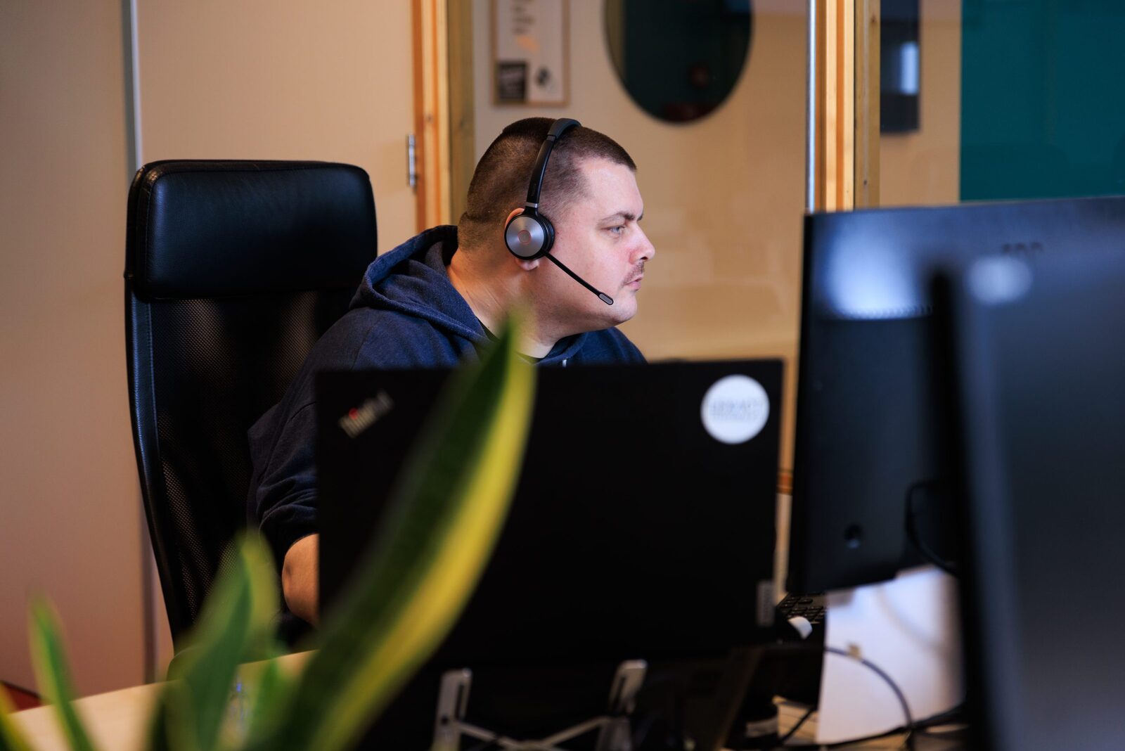 Supportwerkplek met meerdere beeldschermen en headset