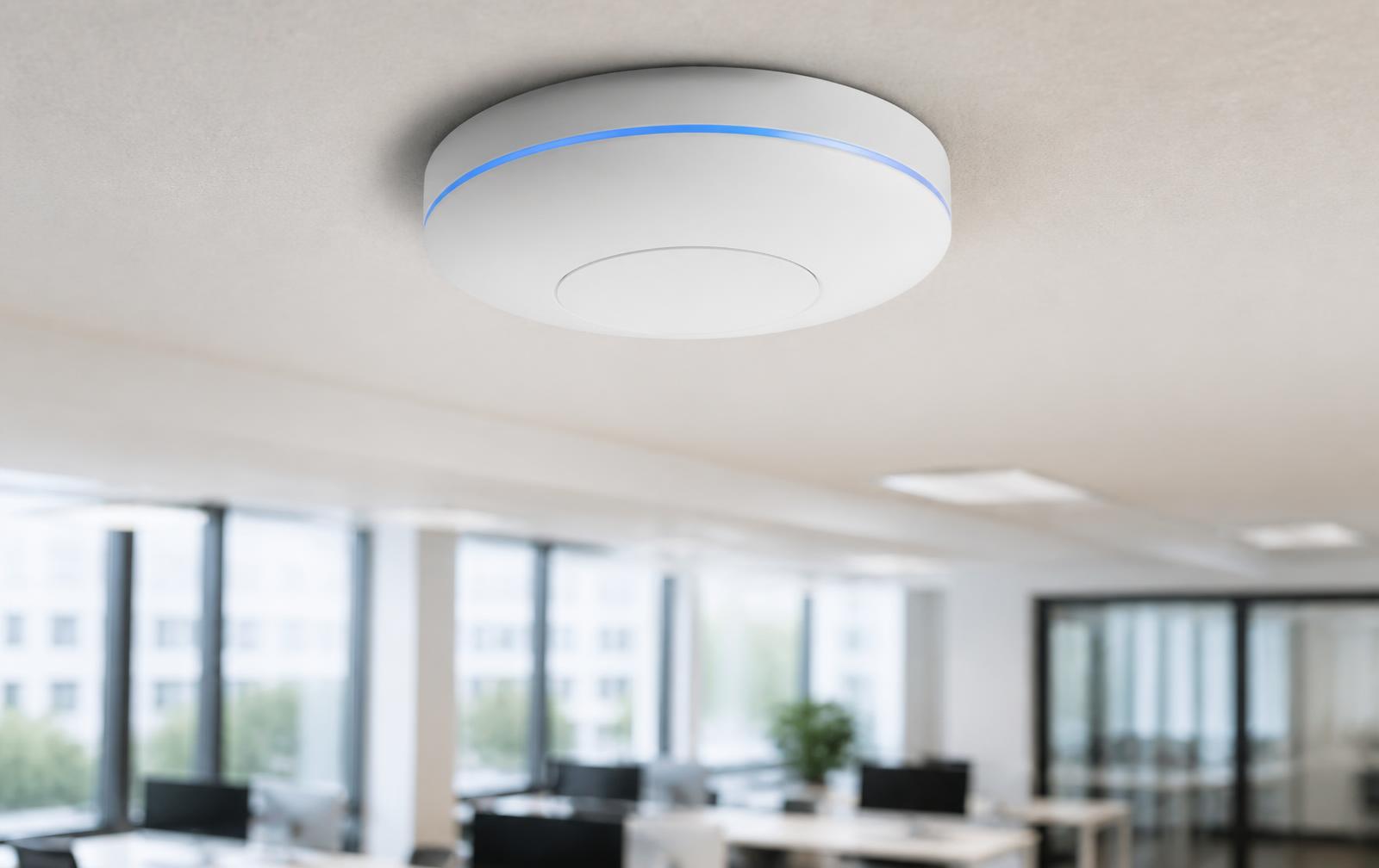 Wifi-accesspoint aan het plafond van een modern kantoor