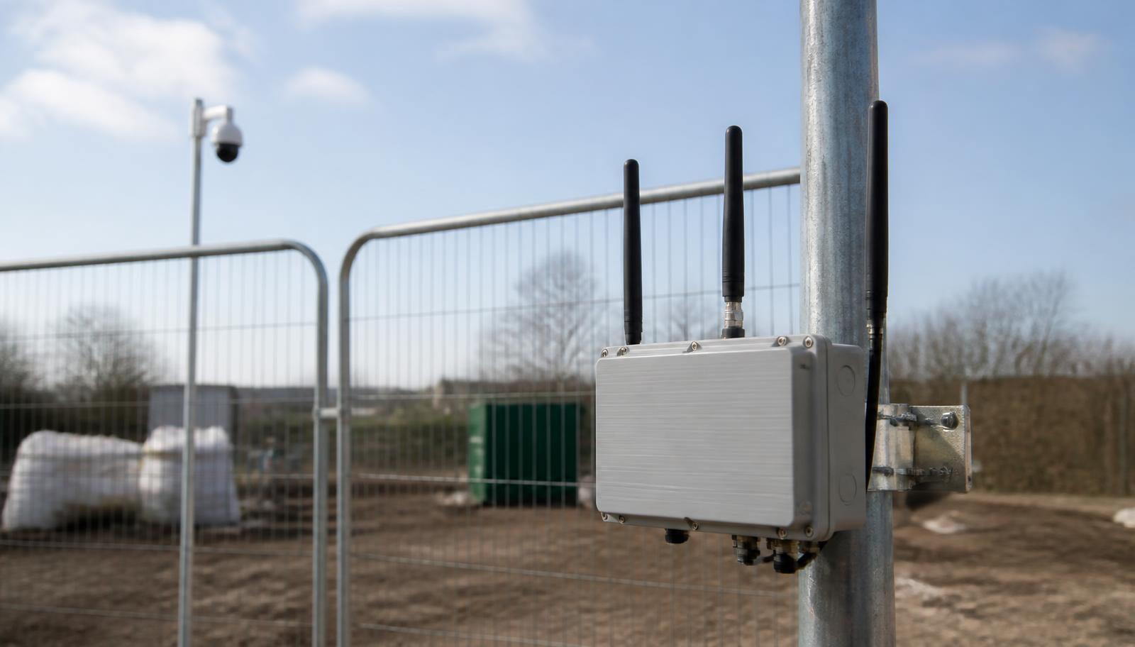 Mobiele 4G-router op een mast bij een tijdelijke locatie met hekwerk en camera