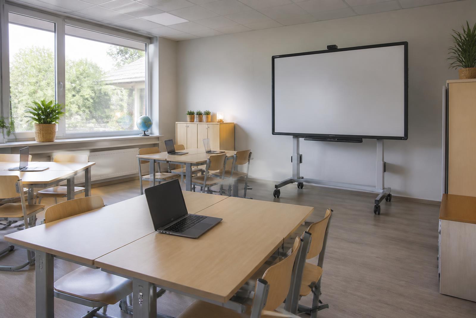 Klaslokaal met laptops en een digitaal schoolbord